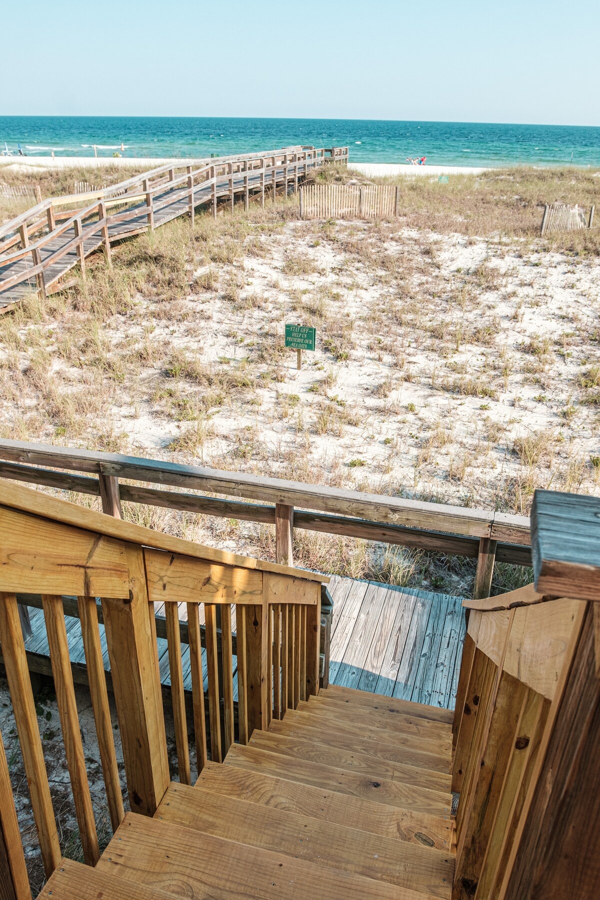 Private stair run connecting balcony level to beach path.